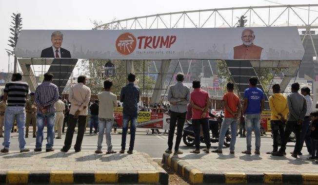 Indians watch workers fix a billboard at an entrance of Sardar Patel stadium ahead of the visit of U.S. President Donald Trump in Ahmedabad, India, Sunday, Feb. 23, 2020. Trump is visiting the city in Gujarat during a two-day trip to India to attend an event called &quot;Namaste Trump,&quot; which translates to &quot;Greetings, Trump,&quot; at a cricket stadium along the lines of a &quot;Howdy Modi&quot; rally attended by Indian Prime Minister Narendra Modi in Houston last September. (AP Photo/Ajit Solanki)