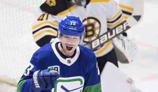 Vancouver Canucks&#39; Tyler Toffoli, front, celebrates his first goal against Boston Bruins goalie Jaroslav Halak, of Slovakia, during the third period of an NHL hockey game Saturday, Feb. 22, 2020, in Vancouver, British Columbia. (Darryl Dyck/The Canadian Press via AP)