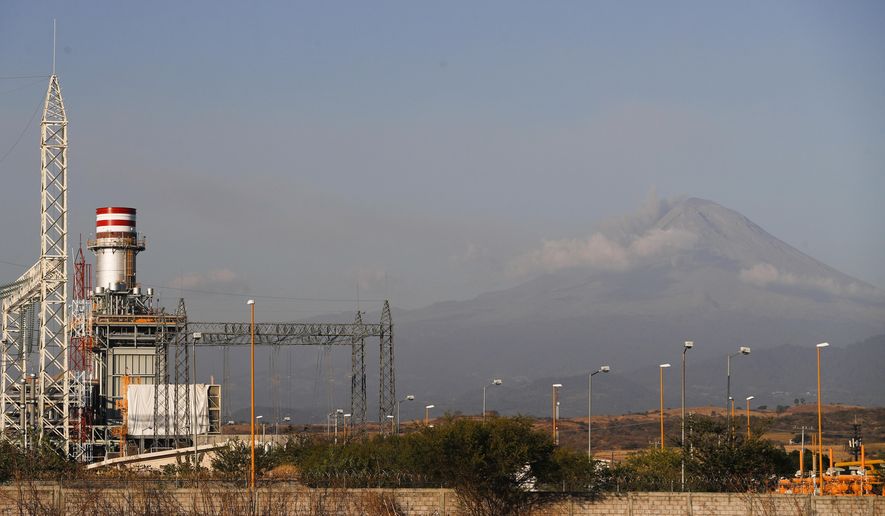 A newly built power generation plant stand idle with the Popocatepetl Volcano in the background, near Huexca, Morelos state, Mexico, Saturday, Feb. 22, 2020. Dozens of mostly indigenous communities along the 159 kilometers of pipeline have united to fight the mega-project they believe will deprive them of water for their crops, while contaminating the soil and air. (AP Photo/Eduardo Verdugo)