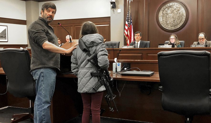 CORRECTS BYLINE TO KEITH RIDLER, NOT KEN RITTER - Charles Nielsen, 58, and his 11-year-old granddaughter, Bailey Nielsen, testify before a House panel at the Idaho Statehouse on Monday. Feb. 24, 2020 in Boise, Idaho. Visitors to Idaho 18 and older who can legally possess firearms would be allowed to carry a concealed handgun within city limits under legislation that headed to the House on Monday, Feb. 24. (AP Photo/Keith Ridler)