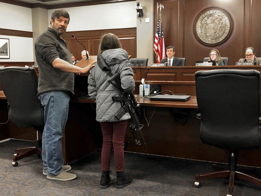 CORRECTS BYLINE TO KEITH RIDLER, NOT KEN RITTER - Charles Nielsen, 58, and his 11-year-old granddaughter, Bailey Nielsen, testify before a House panel at the Idaho Statehouse on Monday. Feb. 24, 2020 in Boise, Idaho. Visitors to Idaho 18 and older who can legally possess firearms would be allowed to carry a concealed handgun within city limits under legislation that headed to the House on Monday, Feb. 24. (AP Photo/Keith Ridler)