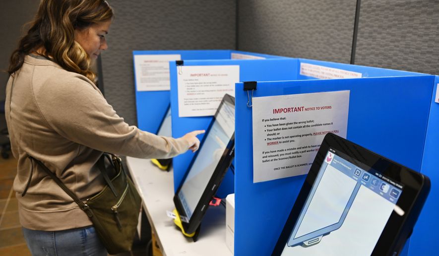 In this Tuesday, Nov. 5, 2019 file photoCourtney Parker votes on a new voting machine, in Dallas, Ga. (AP Photo/Mike Stewart, File)