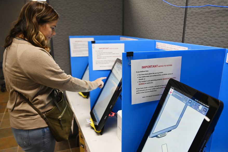 In this Tuesday, Nov. 5, 2019 file photoCourtney Parker votes on a new voting machine, in Dallas, Ga. (AP Photo/Mike Stewart, File)