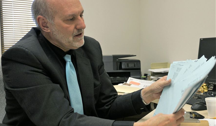 In this Feb. 10, 2020 photo, Minot City Assessor Kevin Ternes holds commercial assessment documents in his office in Minot City, N.D. Ternes plans to retire from the city Feb. 28 and open a commercial appraisal office. (Jill Schramm/Minot Daily News via AP)