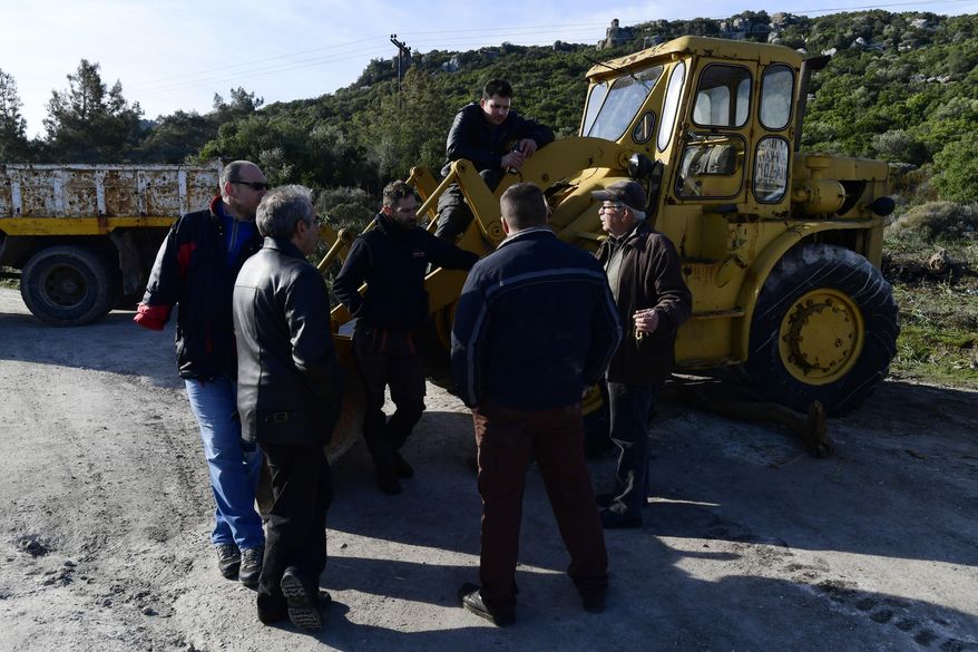 Local residents gather at a roadblock near Mandamados village on the northeastern Aegean island of Lesbos, Greece, Monday, Feb. 24, 2020. Protest groups on three eastern Greek islands have begun setting up blockades aimed at stopping the government from building new migrant detention centers.(AP Photo/Michael Varaklas)