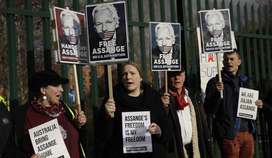 Supporters of Julian Assange hold placards as they protest on the second day of a week of opening arguments for the extradition of Wikileaks founder Julian Assange outside Belmarsh Magistrates&#x27; Court in south east London, Tuesday, Feb. 25, 2020. U.S. authorities, want to try Assange on espionage charges. A lawyer for the Americans said the Australian computer expert was an “ordinary” criminal whose publication of hundreds of thousands of secret military documents put many people at risk of torture and death. (AP Photo/Matt Dunham)