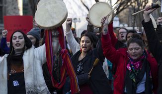 People raise their hands and drums as they rally in solidarity with Wet&#39;suwet&#39;en hereditary chiefs opposed to the Costal GasLink Pipeline, in Ottawa, on Monday, Feb. 24, 2020. (Justin Tang/The Canadian Press via AP)
