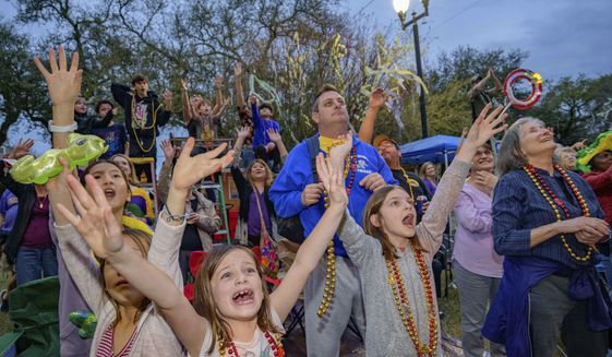 People cry out for beads from floats in the Krewe of Orpheus parade on Napoleon Ave. during Mardi Gras celebrations in New Orleans, Monday, Feb. 24, 2020. (AP Photo/Matthew Hinton)