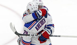 New York Rangers center Mika Zibanejad (93) embraces New York Rangers left wing Chris Kreider (20) after scoring the winning goal in overtime of an NHL hockey game against the New York Islanders, Tuesday, Feb. 25, 2020, in Uniondale, N.Y. The Rangers won 4-3. (AP Photo/Kathy Willens)