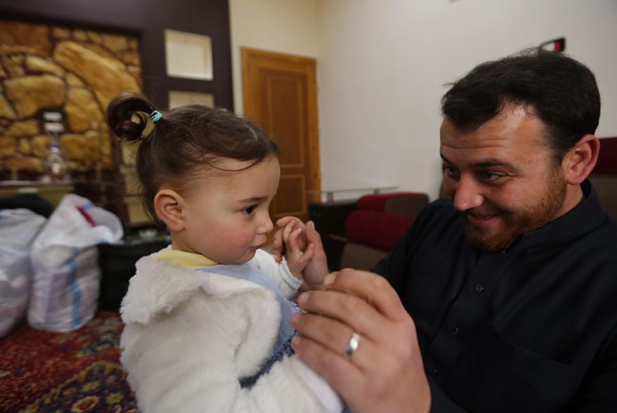 In this Sunday, Feb. 23, 2020, photo, Abdullah Mohammed plays with his daughter, 3-year-old Salwa inside a house he recently fled to, near the Syrian-Turkish border, in Sarmada, Syria. Mohammed would do anything for his daughter, even if that means forcing himself to laugh with her at the sound of exploding bombs, to help her overcome her fear. Mohammed and Salwa became an overnight celebrity after a video they shot spread on social media, widely shared as a reminder of the horrors faced by children in Syria. (AP Photo/Ghaith Alsayed)