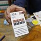 In this June 17, 2019, file photo, a cashier displays a packet of tobacco-flavored Juul pods at a store in San Francisco.  (AP Photo/Samantha Maldonado, File)