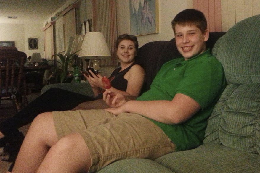 In this July 2016 photo made available by Laurie Giordano, her son Zachary and her daughter Vanessa sit together an an undisclosed location. Zach, a rising junior at a high school in Florida, collapsed while at a football practice in the summer of 2017. He died 11 days later. On Wednesday, April 26, 2020, a Florida legislative committee honored the teenager by renaming a proposed law after him that would put safety measures in place to protect student athletes from deadly heat strokes. (Laurie Giordano via AP)