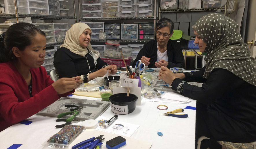 This May 15, 2019 photo shows A Little Something participants Khei Hung from Burma, left, Sabah Almobarak from Syria, Eh Gay Ju from Burma, and Mounira Kuru from Syria, as they work through frustration and creative challenges in their first lesson making wire-wrapped necklace pendants in Aurora, Colo. A Little Something helps women refugees turn their crafts into dollars. Around the world there are organizations that use crafting and the arts as tools to help refugees build community and learn new skills. (Sharon L. McCreary via AP)