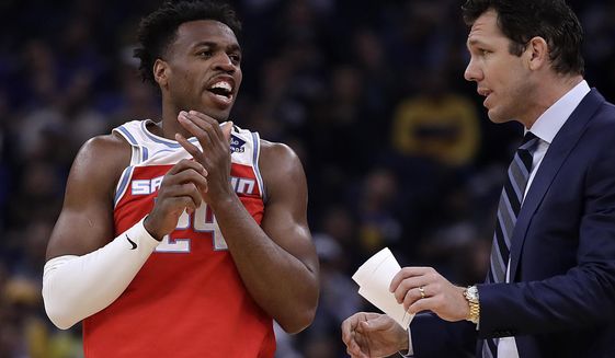 Sacramento Kings&#39; Buddy Hield, left, speaks with coach Luke Walton during the first half of an NBA basketball game against the Golden State Warriors Tuesday, Feb. 25, 2020, in San Francisco. (AP Photo/Ben Margot)