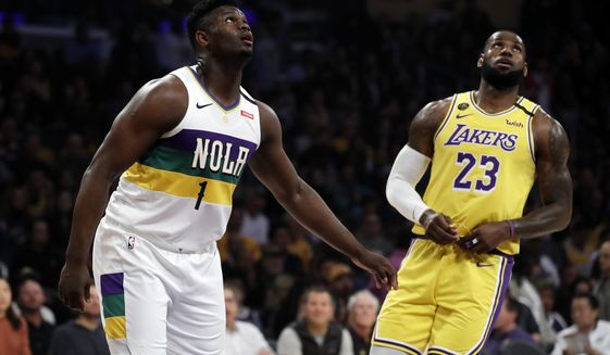 New Orleans Pelicans&#39; Zion Williamson (1) looks on from under the basket during free throws next to Los Angeles Lakers&#39; LeBron James (23) during the first half of an NBA basketball game Tuesday, Feb. 25, 2020, in Los Angeles. (AP Photo/Marcio Jose Sanchez)