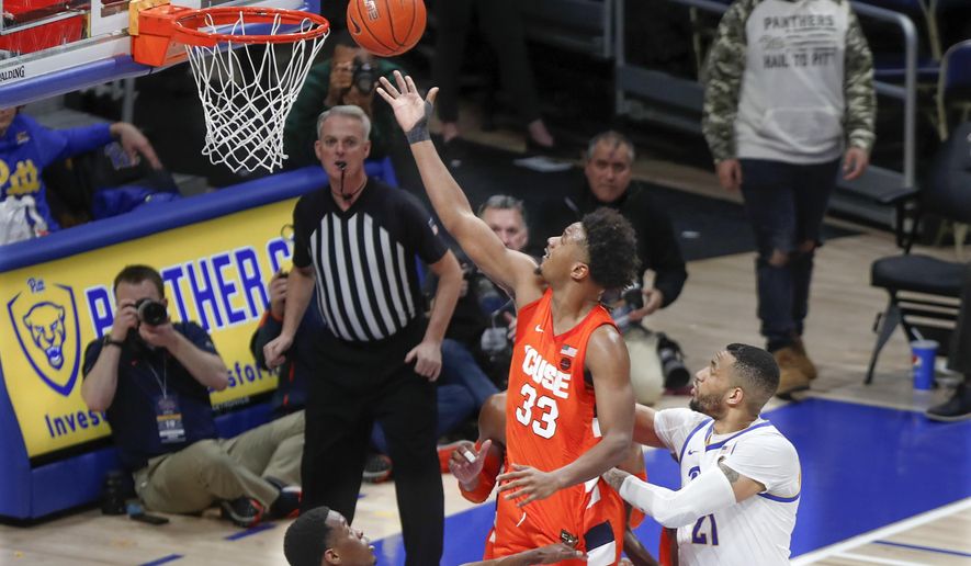 Syracuse&#x27;s Elijah Hughes (33) scores after getting by Pittsburgh&#x27;s Terrell Brown (21) during the second half of an NCAA college basketball game, Wednesday, Feb. 26, 2020, in Pittsburgh. (AP Photo/Keith Srakocic)