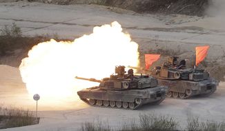 FILE - In this April 26, 2017, file photo, U.S. Army&#39;s M1 A2 tanks fire during South Korea-U.S. joint military live-fire drills at Seungjin Fire Training Field in Pocheon, South Korea, near the border with North Korea. The South Korean and U.S. militaries have postponed on Thursday, Feb. 27, 2020, their annual joint drills out of concerns over a virus outbreak. (AP Photo/Ahn Young-joon, File)