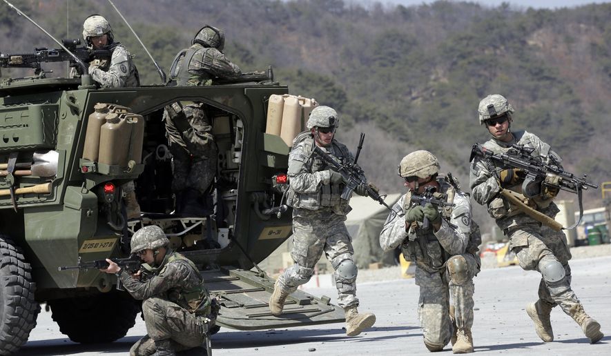 In this March 25, 2015, photo, U.S. Army soldiers from the 25th Infantry Division&#x27;s 2nd Stryker Brigade Combat Team and South Korean soldiers take their positions during a demonstration of the combined arms live-fire exercise as part of the annual joint military exercise between South Korea and the United States at the Rodriquez Multi-Purpose Range Complex in Pocheon, north of Seoul, South Korea. The South Korean and U.S. militaries have postponed on Thursday, Feb. 27, 2020, their annual joint drills out of concerns over a virus outbreak. (AP Photo/Lee Jin-man) **FILE**
