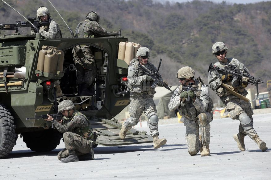 In this March 25, 2015, photo, U.S. Army soldiers from the 25th Infantry Division&#39;s 2nd Stryker Brigade Combat Team and South Korean soldiers take their positions during a demonstration of the combined arms live-fire exercise as part of the annual joint military exercise between South Korea and the United States at the Rodriquez Multi-Purpose Range Complex in Pocheon, north of Seoul, South Korea. The South Korean and U.S. militaries have postponed on Thursday, Feb. 27, 2020, their annual joint drills out of concerns over a virus outbreak. (AP Photo/Lee Jin-man) **FILE**