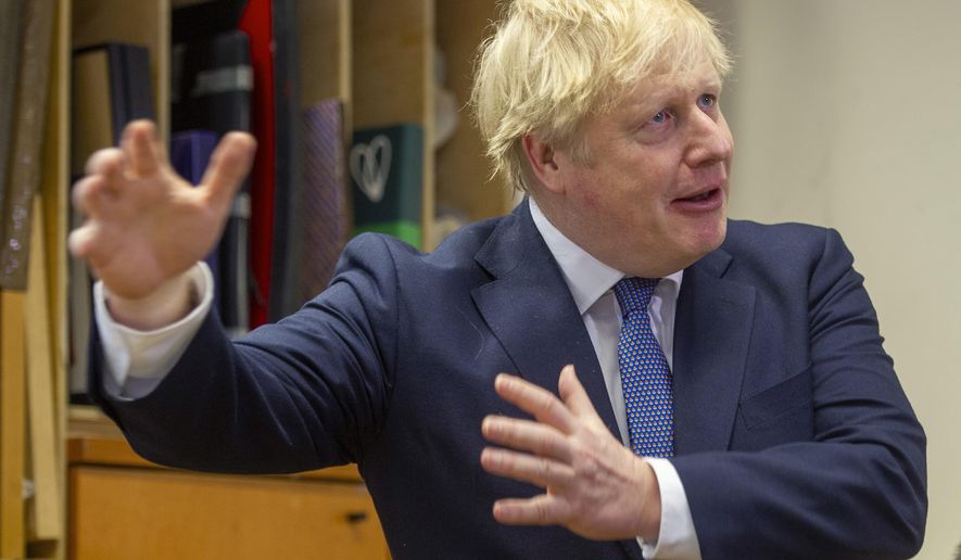 Britain's Prime Minister Boris Johnson gestures during a visit to the Connection, a homelessness centre, at St Martins in the Fields, London, Thursday, Feb. 27, 2020. (Tim Clarke/Pool Photo via AP)