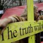 A supporter leans on a wooden cross which reads &amp;quot;The truth will win&amp;quot; as he protests against the extradition of Wikileaks founder Julian Assange outside Belmarsh Magistrates Court in London, Monday, Feb. 24, 2020. The U.S. government and Assange will face off Monday over extradition, a decade after WikiLeaks infuriated American officials by publishing a trove of classified government documents. (AP Photo/Matt Dunham)