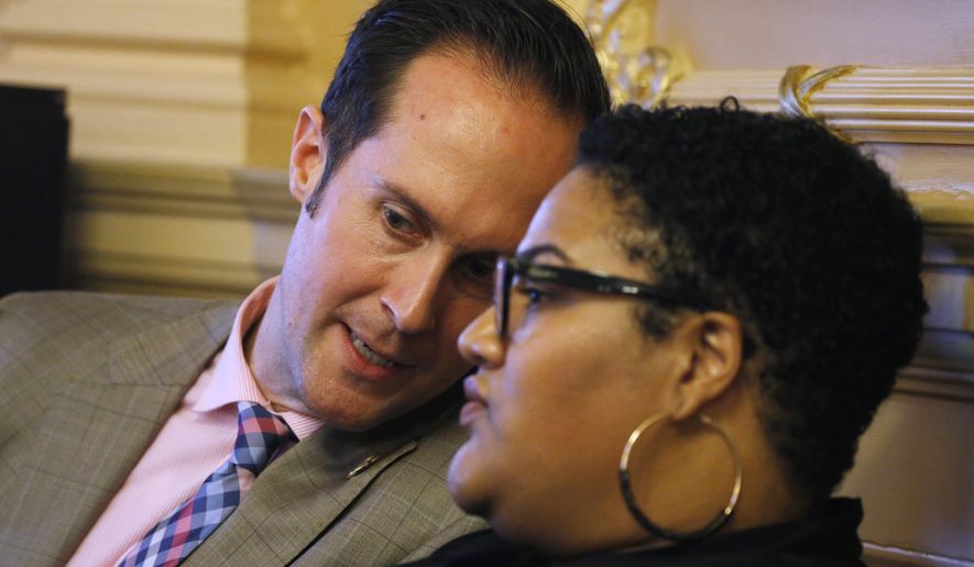 Del. Schuyler VanValkenburg, D-Henrico, left, talks with Del. Marcia 'Cia' Price, D-Newport News, right, during the House session at the Capitol Tuesday, Feb. 25, 2020, in Richmond, Va. Virginia Democrats made nonpartisan redistricting a key campaign plank during last year's off-year election, when they won full control of the statehouse for the first time in a generation. Now in power, they may not pass any reform measures because of internal party divisions. (AP Photo/Steve Helber)