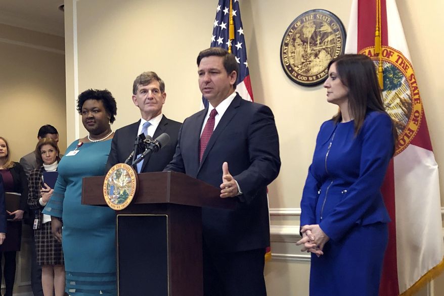 Florida Gov. Ron DeSantis speaks during a news conference as Deputy Secretary for Health Dr. Shamarial Roberson, left, Florida Surgeon General Dr. Scott Rivkees, second from left, and Lt. Gov. Jeanette Nuñez, right, listen, Thursday, Feb. 27, 2020, in Tallahassee, Fla. DeSantis attempted to reassure his state Thursday that health officials were prepared for any cases of a new virus that has killed thousands worldwide, saying there were no confirmed cases — yet — of infections from COVID-19. (AP Photo/Bobby Caina Calvan