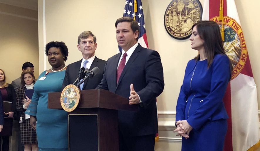 Florida Gov. Ron DeSantis speaks during a news conference as Deputy Secretary for Health Dr. Shamarial Roberson, left, Florida Surgeon General Dr. Scott Rivkees, second from left, and Lt. Gov. Jeanette Nuñez, right, listen, Thursday, Feb. 27, 2020, in Tallahassee, Fla. DeSantis attempted to reassure his state Thursday that health officials were prepared for any cases of a new virus that has killed thousands worldwide, saying there were no confirmed cases — yet — of infections from COVID-19. (AP Photo/Bobby Caina Calvan)