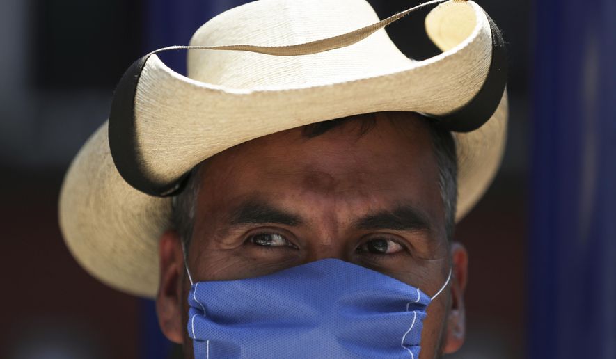 A street vendor wears a mask over his mouth as a precaution against the spread of the new coronavirus in Mexico City, Friday, Feb. 28, 2020. Mexico&#39;s assistant health secretary announced Friday that the country now has confirmed cases of the COVID-19 virus. (AP Photo/Fernando Llano)