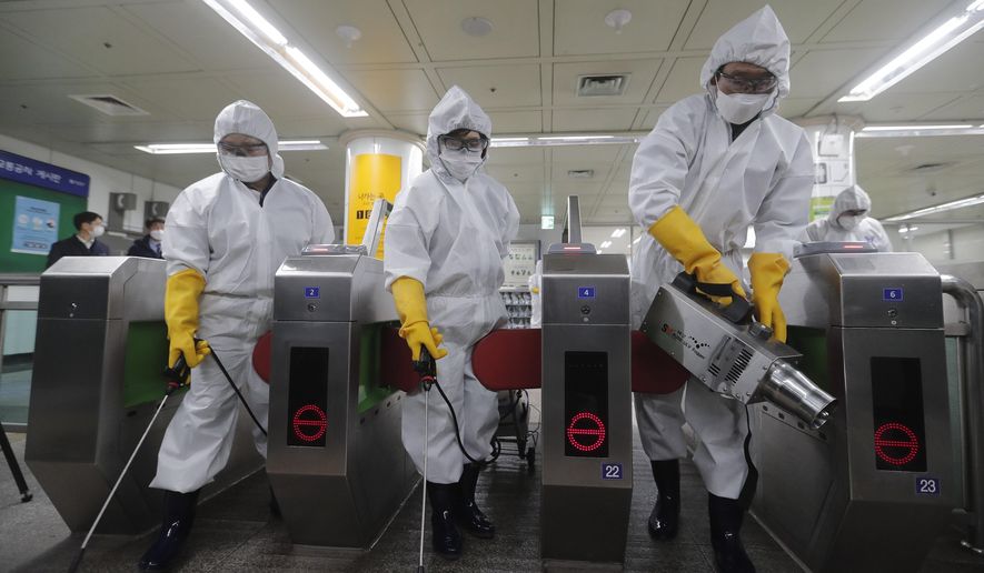 Workers wearing protective gears spray disinfectant as a precaution against the new coronavirus at a subway station in Seoul, South Korea, Friday, Feb. 28, 2020. Japan's schools prepared to close for almost a month and entertainers, topped by K-pop superstars BTS, canceled events as a virus epidemic extended its spread through Asia into Europe and on Friday, into sub-Saharan Africa. (AP Photo/Ahn Young-joon)