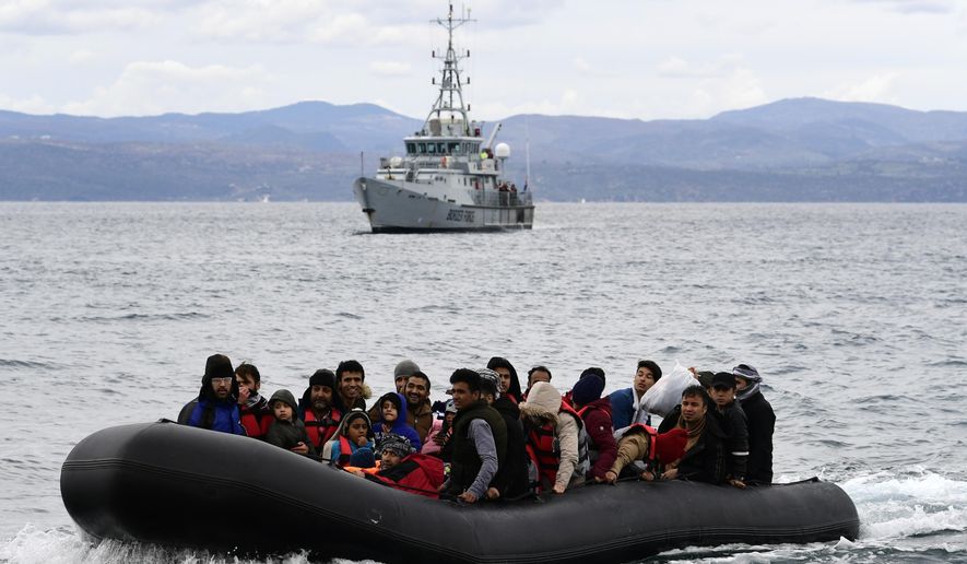 Migrants arrive with a dinghy accompanied by a Frontex vessel at the village of Skala Sikaminias, on the Greek island of Lesbos, after crossing the Aegean sea from Turkey, on Friday, Feb. 28, 2020. An air strike by Syrian government forces killed scores of Turkish soldiers in northeast Syria, a Turkish official said Friday, marking the largest death toll for Turkey in a single day since it first intervened in Syria in 2016. (AP Photo/Michael Varaklas)