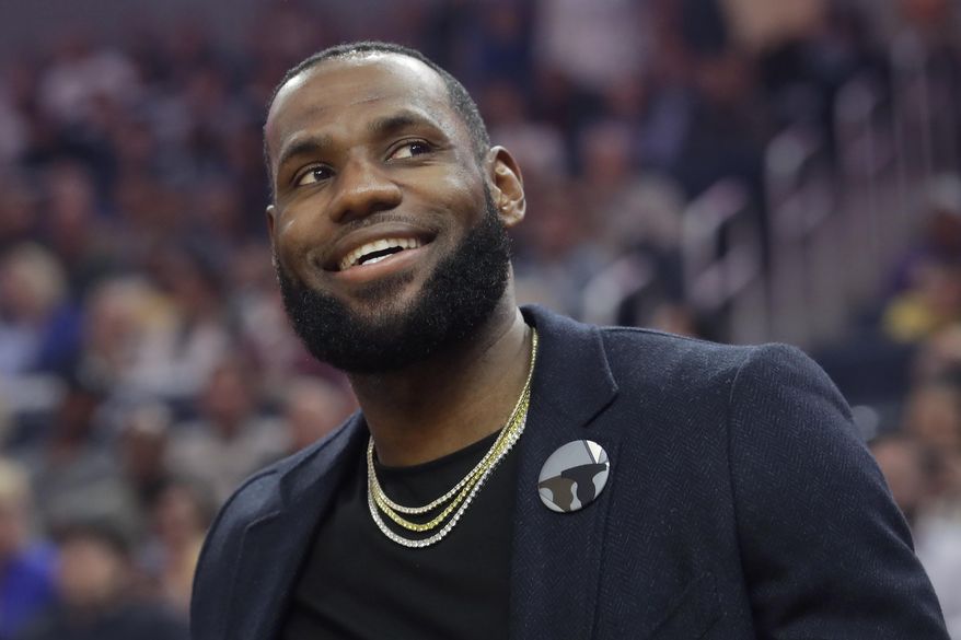 Injured Los Angeles Lakers forward LeBron James smiles from the bench during the first half of an NBA basketball game between the Golden State Warriors and the Lakers in San Francisco, Thursday, Feb. 27, 2020. (AP Photo/Jeff Chiu)