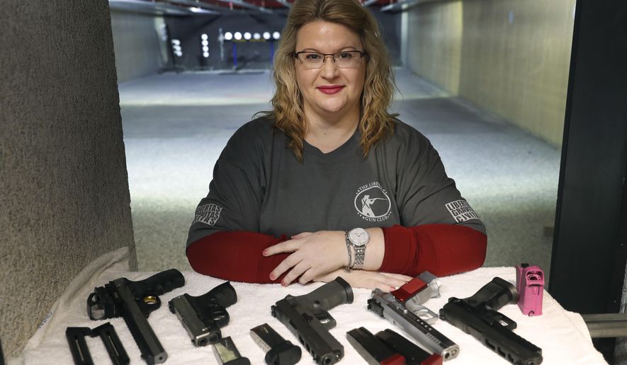 In this Wednesday, Feb. 5, 2020, photo, Kat Ellsworth of Chicago, poses for a portrait with five of the seven guns she owns at the Caliber Tactical Gun Range in Waukegan, Ill. Ellsworth was firmly against firearms and favored gun-control until just a few years ago when she went with a friend to a gun range and discovered a love for firearms and shooting. (AP Photo/Charles Rex Arbogast)