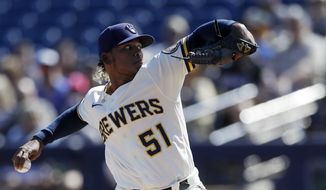 Milwaukee Brewers starting pitcher Freddy Peralta works against a Seattle Mariners batter during the first inning of a spring training baseball game Tuesday, Feb. 25, 2020, in Phoenix. (AP Photo/Gregory Bull)