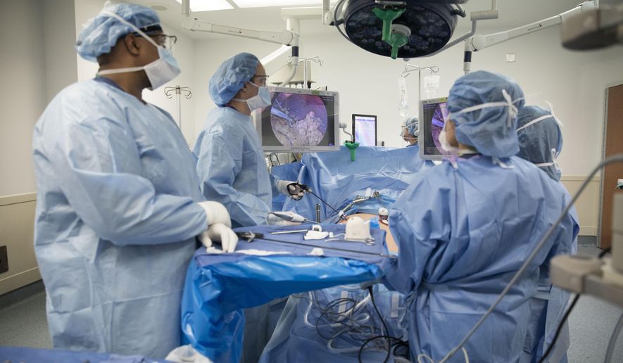 In this Monday, Dec. 16, 2019 photo, Dr. Neil Floch, second from left, performs gastric bypass surgery laparoscopically, using monitors to guide him at Nuvance Health&#39;s hospital in Norwalk, Conn. Obesity surgery is becoming a more common way to lose weight, and so is the likelihood of patients getting a second surgery. In 2019, an estimated 15% of all obesity surgeries in the U.S. came after a previous procedure, up from 6% in 2011, according to a surgeons&#39; group. (AP Photo/Kathy Young)