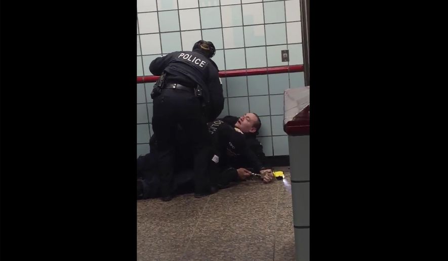 This Friday, Feb. 28, 2020 image from cellphone video shows Chicago police officers trying to apprehend a suspect inside a downtown Chicago train station. After a struggle with police, the suspect was shot as he fled up the escalator with the officers in pursuit.  Mayor Lori Lightfoot said video footage of police shooting and wounding the suspect is “extremely disturbing” and that she supports the interim police superintendent&#39;s request for prosecutors to be sent directly to the scene.   (Michael McDunnah via AP)