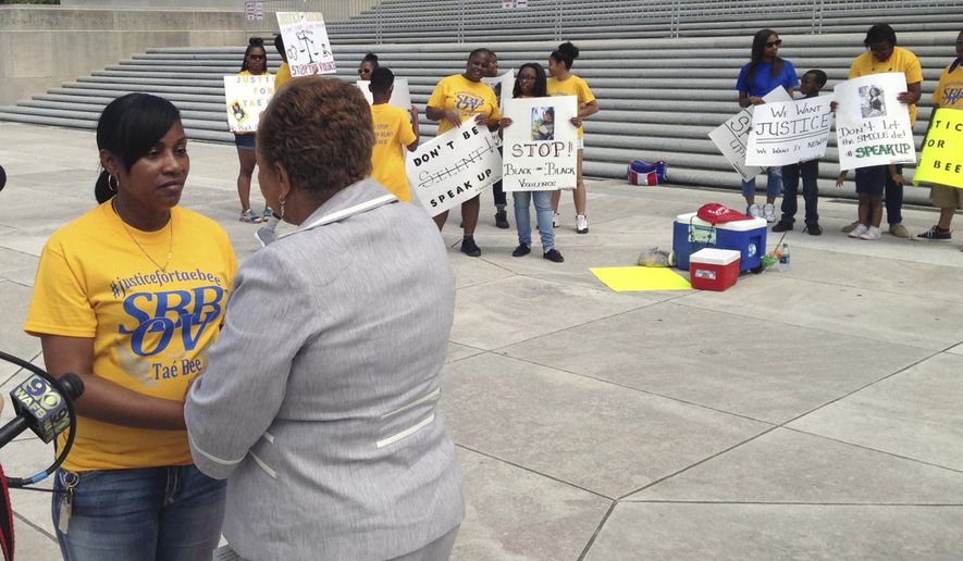 FILE - This May 26, 2016, file photo shows Theresa Tillman, left, listening to Sen. Yvonne Dorsey-Colomb, D- Baton Rouge, as she speaks at an anti-violence rally on the steps on the Louisiana State Capitol in Baton Rouge, La. Tillman, a recent Sowela Technical Community College graduate, has her sights set on more than just personal improvement with the attainment of her degree. Her aim is also total criminal justice reform, she said. Tillman's daughter, LaShuntae Benton, was killed at a college party in 2016. The alleged shooter has yet to be convicted, she said. (AP Photo/Michael Kunzelman, File)