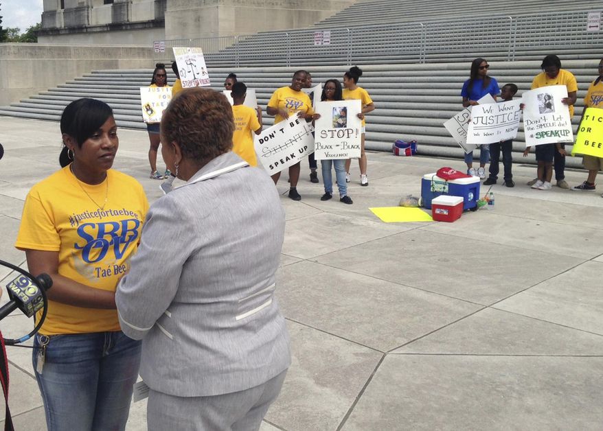 FILE - This May 26, 2016, file photo shows Theresa Tillman, left, listening to Sen. Yvonne Dorsey-Colomb, D- Baton Rouge, as she speaks at an anti-violence rally on the steps on the Louisiana State Capitol in Baton Rouge, La. Tillman, a recent Sowela Technical Community College graduate, has her sights set on more than just personal improvement with the attainment of her degree. Her aim is also total criminal justice reform, she said. Tillman's daughter, LaShuntae Benton, was killed at a college party in 2016. The alleged shooter has yet to be convicted, she said. (AP Photo/Michael Kunzelman, File)