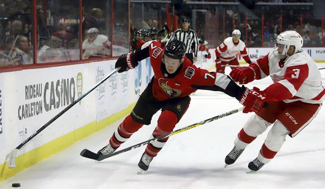 Ottawa Senators left wing Brady Tkachuk (7) and Detroit Red Wings defenseman Alex Biega (3) vie for control of the puck during second period NHL hockey action in Ottawa, Saturday, Feb. 29, 2020. (Fred Chartrand/The Canadian Press via AP)