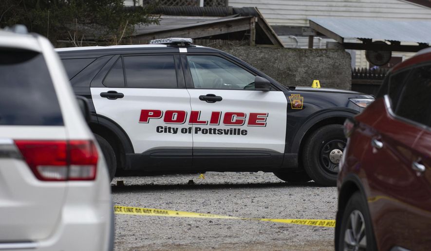 A Pottsville police car is surrounded by police tape and evidence markers at the back of Woody's Bar and Backyard Paradise, in Pottsville, Pa., after an early morning shooting on Saturday, Feb. 29, 2020. Authorities say a shooting outside the eastern Pennsylvania bar sent several people to medical facilities for treatment. (David McKeown/Republican-Herald via AP)