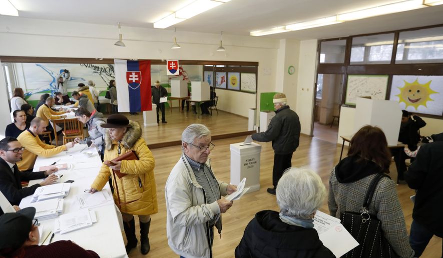 People vote at a polling station during general elections in Trnava, Slovakia, Saturday, Feb. 29, 2020. Slovaks vote Saturday in parliamentary elections widely expected to unseat the country&#x27;s long-dominant but scandal-tainted center-left party that governed on an anti-immigration platform, in favor of a coalition headed by center-right populists. (AP Photo/Petr David Josek)