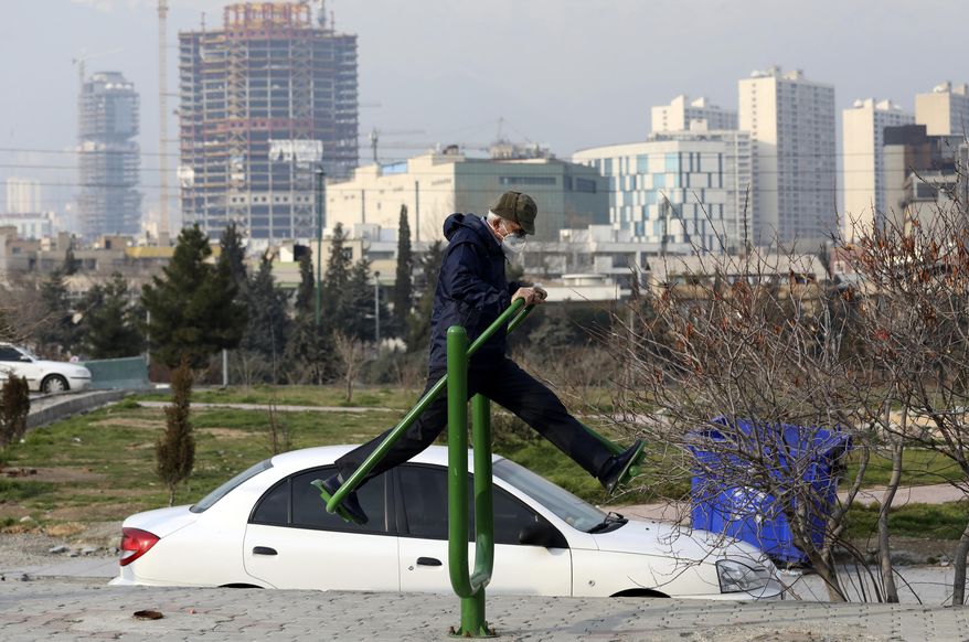 A man with a mask exercises as he spends his weekend afternoon at Pardisan Park in Tehran, Iran, Friday, Feb. 28, 2020. Iranians in Tehran on Friday found time to enjoy their weekend, even as authorities canceled Friday prayers and closed universities, schools and parliament over fears about the new coronavirus. (AP Photo/Vahid Salemi)