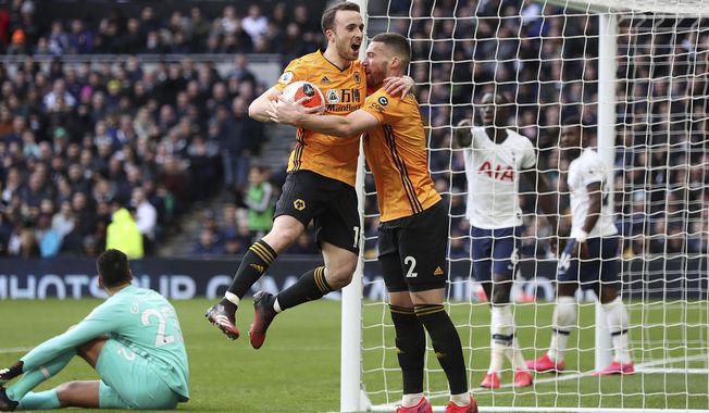 Wolverhampton Wanderers' Diogo Jota, center left, celebrates scoring his side's second goal of the game with teammate Matt Doherty during the English Premier League soccer match between Tottenham and Wolverhampton Wanderers at the Tottenham Hotspur Stadium, London, Sunday, March 1, 2020. (Bradley Collyer/PA via AP)