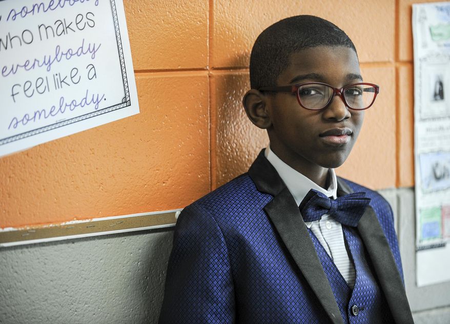 In this Thursday, Feb. 27, 2020, photo, Jayden Bunbury plays the role of composer and musician W.C. Handy during Black History Month's wax museum at Chestnut Grove Elementary School in Decatur, Ala. Instead of the usual assembly, Chestnut Grove students played the roles of famous black and white people who contributed to the civil rights movement and black people who have made significant contributions to history. (Jeronimo Nisa/The Decatur Daily via AP)