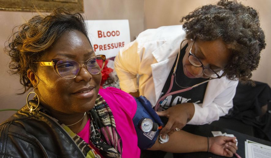 Jamilla Pinder has her blood pressure checked by Debra Barnes at the Hair, Heart and Health kick-off at Hot Seat Studio and Salon in Greensboro, N.C., on Monday, Feb. 24, 2020. (Woody Marshall/News & Record via AP)