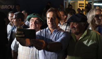 Uruguay’s President-elect Luis Lacalle Pou takes a selfie with supporters at the Rural Association where gauchos are gathering ahead of their official participation in the upcoming inaugural festivities, in Montevideo, Uruguay, Saturday, Feb. 29, 2020. Lacalle Pou, a 46-year-old lawyer and a former senator, will be sworn-in as the country&#39;s new president on Sunday. (AP Photo/Matilde Campodonico)