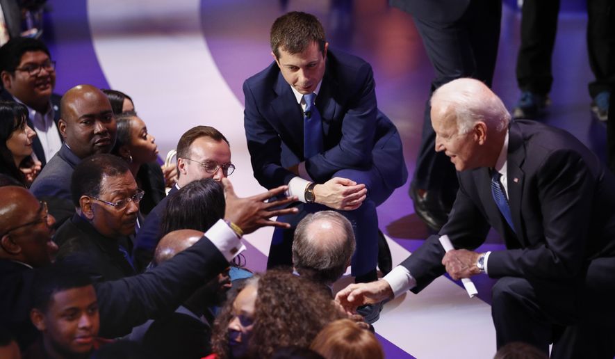 Democratic presidential candidates, former South Bend Mayor Pete Buttigieg, left, and former Vice President Joe Biden, right, greet supporters at the end of the Democratic presidential primary debate at the Gaillard Center, Tuesday, Feb. 25, 2020, in Charleston, S.C., co-hosted by CBS News and the Congressional Black Caucus Institute. (AP Photo/Patrick Semansky)