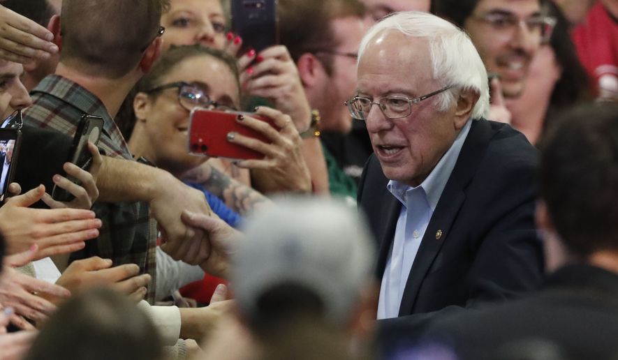 FILE - In this Sunday, Feb. 16, 2020, file photo, Democratic presidential candidate Sen. Bernie Sanders, I-Vt., right, poses for a photograph with a supporter after a campaign stop in Denver. Colorado voters will cast their ballots in the state's primary election Tuesday, March 3. (AP Photo/David Zalubowski, File)