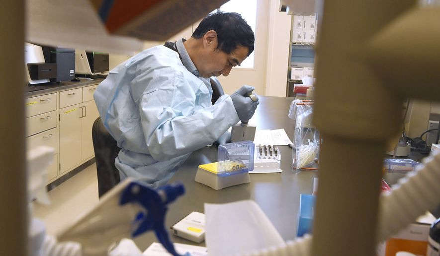 Microbiologist Xiugen Zhang runs a Polymerase Chain Reaction (PCR) test at the Connecticut State Public Health Laboratory, Monday, March 2, 2020, in Rocky Hill, Conn. The Connecticut Department of Public Health has received federal approval from the Centers for Disease Control and Prevention and the Food and Drug Administration to run diagnostic testing for the coronavirus at the department's lab in Rocky Hill. (AP Photo/Jessica Hill)