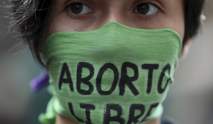 A pro-abortion activist protests in front of Colombia's Constitutional Court in Bogota, Colombia, Monday, March 2, 2020. Protesters gathered in front of Colombia's Constitutional Court ahead of an expected ruling that could allow more women to access abortion if approved. (AP Photo/Fernando Vergara)